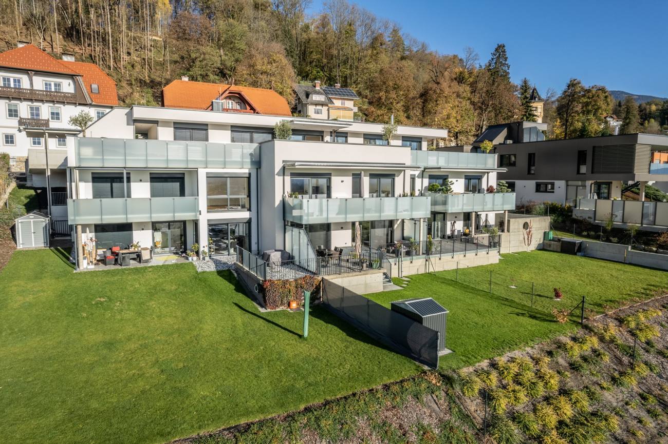 Wohnanlage am Hang mit Glasbalkonen, Terrassen und Gärten, Luftansicht